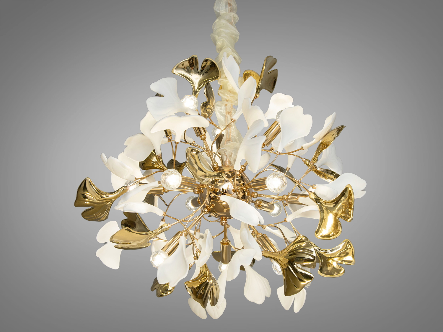 Ця новинка, люстра з фарфоровими елементами є втіленням вишуканості та дизайнерської думки, в якій вдало поєднуються ехо давньої мудрості та сучасні тенденції інтер'єрного мистецтва. Міцний металевий каркас керамічної люстри, який служить основою для ніжних керамічних пелюсток, оформлених у формі листя Гінкго Білоба, робить цю люстру не лише міцною та довговічною, а й наповнює її символікою довголіття та непереможної краси.
Купить люстру в Україні недорого від виробника, ви отримуєте не лише якісне освітлення в вашій оселі, але й зручність та практичність у підборі освітлювальних рішень для кожної кімнати з економією на люстри гуртом.
Неглазуровані білі пелюстки з фарфору-бісквіту, які нагадують мармур античних палаців, додають інтер'єру відчуття стабільності та історичної глибини. Вони втілюють спокій та розслаблення, створюючи ефект природної гармонії в будь-якому просторі, де вони з'являються.
Золоті та хромовані пелюстки з глазур'ю під металік додають сучасних акцентів, створюючи розкішний блиск, який ідеально гармонує зі світлом лампочки E14. Ця гра світла та тіні вносить в інтер'єр атмосферу унікальності та витонченості.
Регульована висота люстри дозволяє ідеально адаптувати її розміщення залежно від потреб простору, забезпечуючи оптимальне освітлення і затишок у вашому домі. Люстра стане центральним елементом декору, додавши інтер'єру стиль, елегантність та чарівність.
Фарфорова люстра в вітальню створить особливу атмосферу для прийому гостей, де кожна деталь відіграє роль у створенні загального враження. В кабінеті вона допоможе створити середовище концентрації та інтелектуального праці, де кожен предмет відіграє свою функціональну роль.
Керамічна люстра в зал стане справжнім виразом розкоші та гостинності, а в кухні допоможе поєднати практичність із сучасним дизайном, додаючи простору яскравість та оригінальність. Для тих, хто шукає купити люстру в спальню, ця модель забезпечить ідеальне освітлення для релаксації та відпочинку.
Купити люстру недорого можна в Епіцентрі, де представлений широкий вибір освітлювальних рішень для будь-якого смаку та бюджету. Для жителів Харкова покупка цієї люстри виявиться простою та зручною, адже місто пропонує чудові можливості для шанувальників дизайнерських новинок від ТМ &laquo;Діаша&raquo;.
Цей світильник ідеально підходить для інтер'єрів, де цінується симбіоз класики та модерну, де традиційні форми поєднуються з сучасними матеріалами, створюючи новітній вигляд класичних просторів. Він також ідеально впишеться в інтер'єри стилів ар-нуво або ар-деко, де кожен елемент декору відіграє важливу роль у створенні неповторної атмосфери приміщення.
Чудовим дизайнерським рішенням, було б придбання всього комплекту із серії &laquo;Гінкго Білоба&raquo;. До нього входить: люстра круглої форми, люстра витягнутої форми, бра, торшер, настільний світильник.
Лампи в комплект не входять.